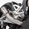 Close-up of motorcycle exhaust and rear wheel.